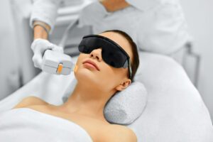 Woman laying on spa bed wearing protective eye shades while receiving IPL Photo Facial in Boca Raton