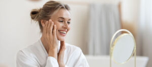 Smiling attractive blonde middle aged woman in white bathrobe - prp facial in Boca Raton concept